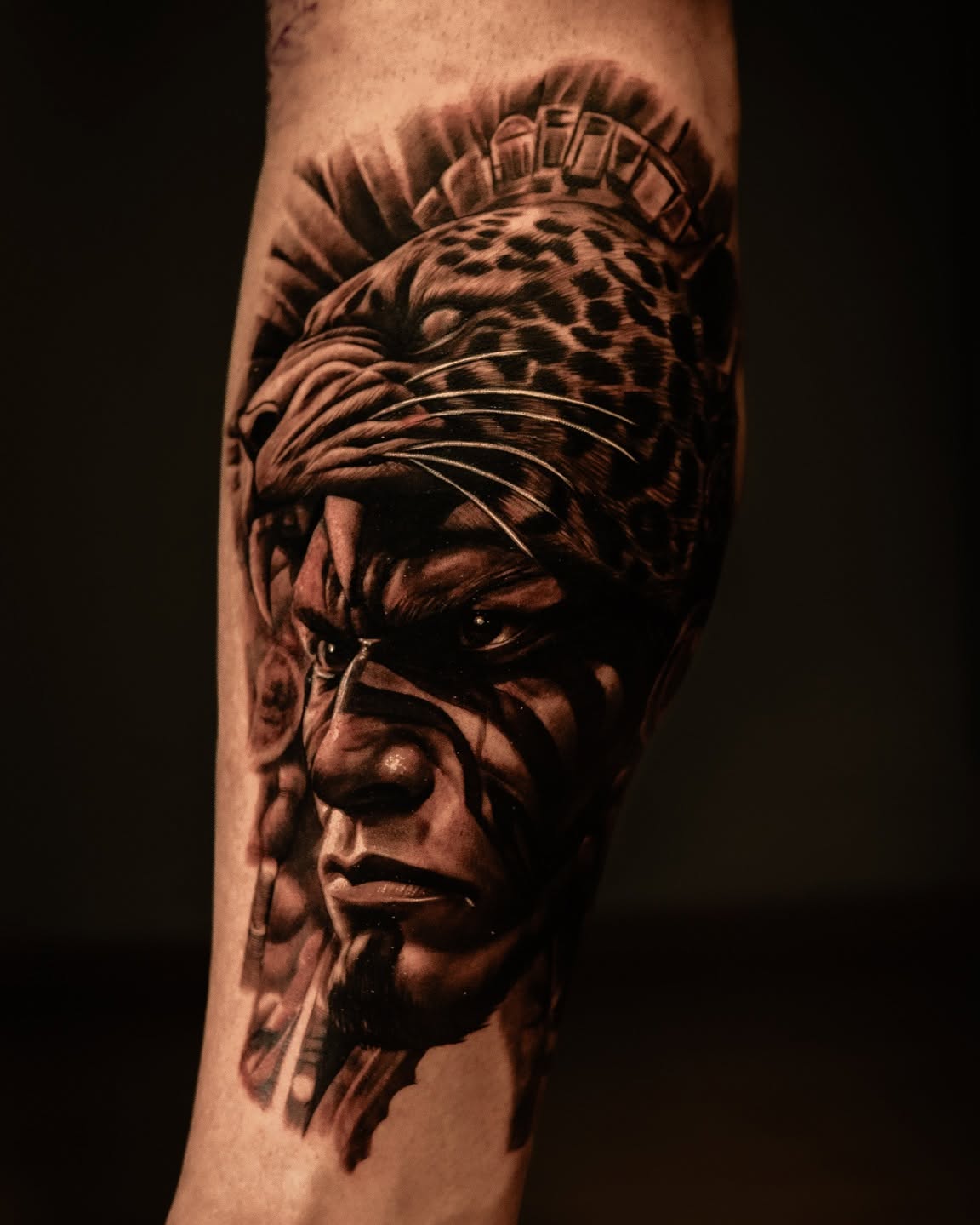 Tatuaje realista de guerrero jaguar mexica en antebrazo, black and gray